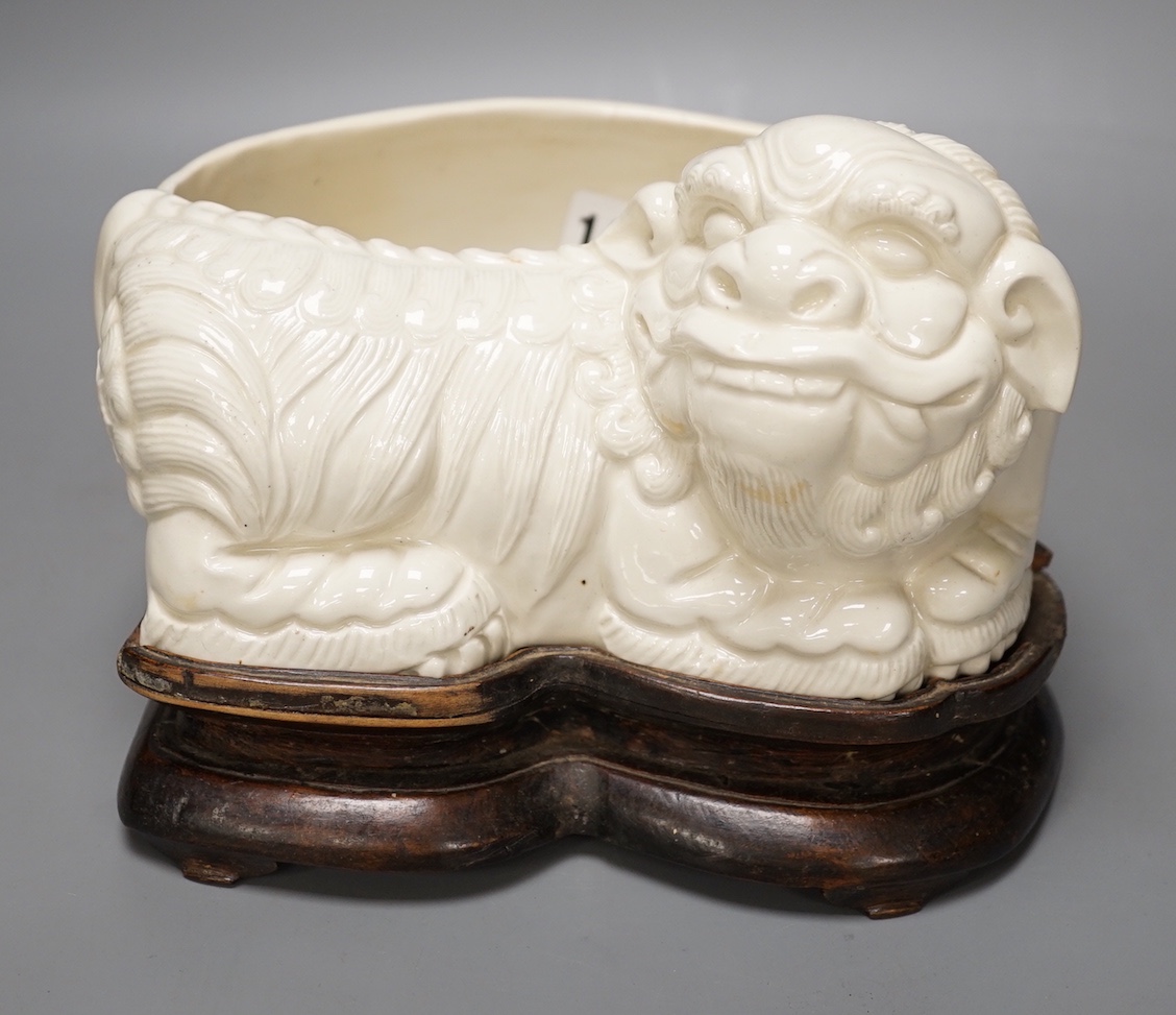 A Chinese cream glazed lion’dog planter on hardwood stand, 21cm